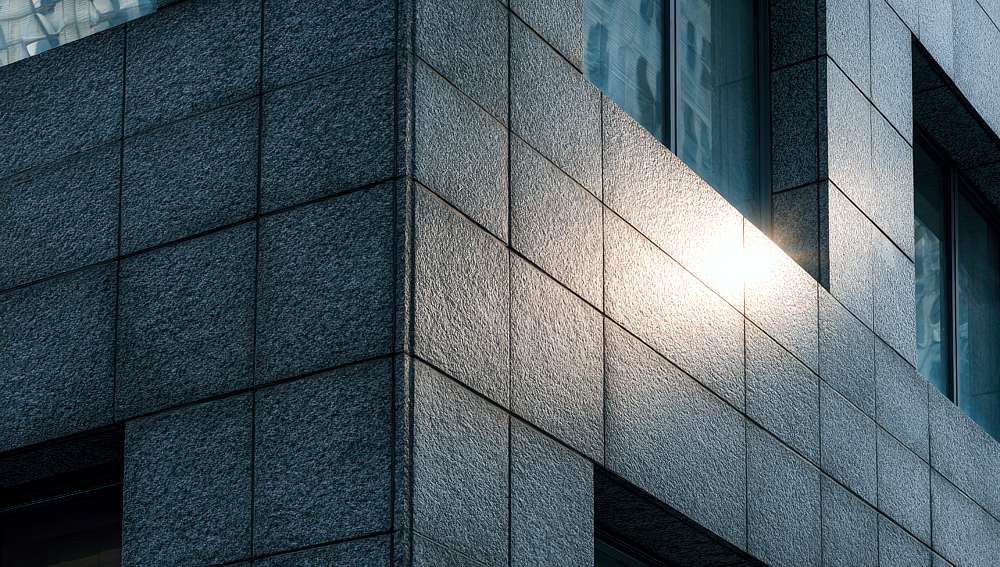 corner of a modern building with gray stone facade